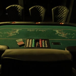 Casino night event setup with blackjack and roulette tables, professional dealers, and vibrant lighting creating a lively party atmosphere.