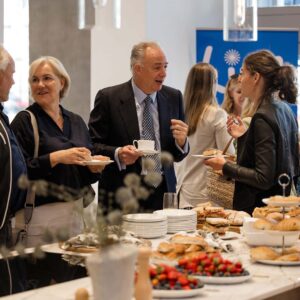 Professionals networking and socializing at a stylish corporate mixer with drinks, ambient lighting, and elegant décor.