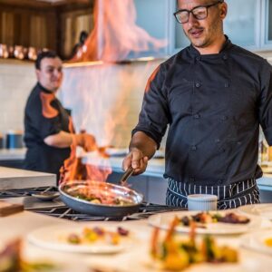 Private chef plating a gourmet dish in an intimate dining setting with candlelight and elegant table décor.
